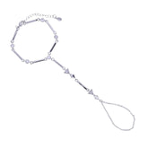 A silver-toned geometric handchain featuring a main hexagonal ring, elongated bar segments, small circular beads, and dangling triangular charms with an adjustable chain extender.