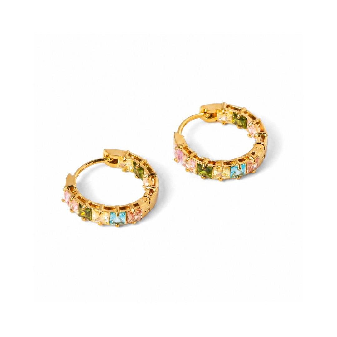 A pair of gold hoop earrings embellished with small, colorful square gemstones in pink, green, and light blue, set against a plain white background.